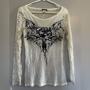 Cream shirt with lace arms, lace back, with a rose and wings design on front.